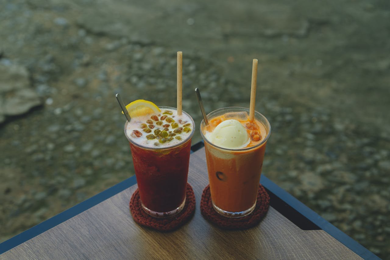 services-02 Two colorful and refreshing drinks with ice and lemon on a wooden table in Ho Chi Minh City.